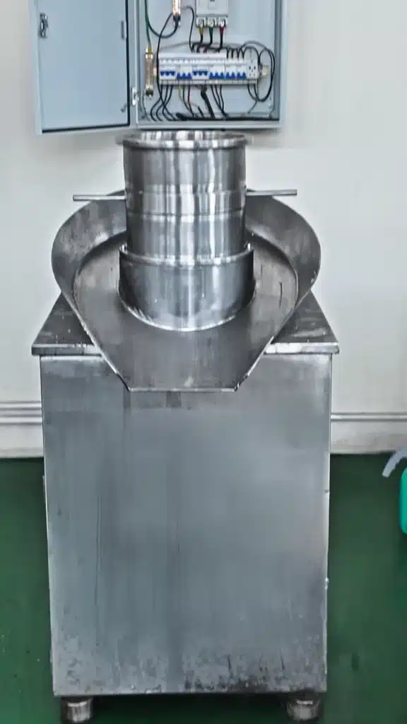 Rotary basket granulator extruding fine sugar powder through a precision screen into uniform wet granules