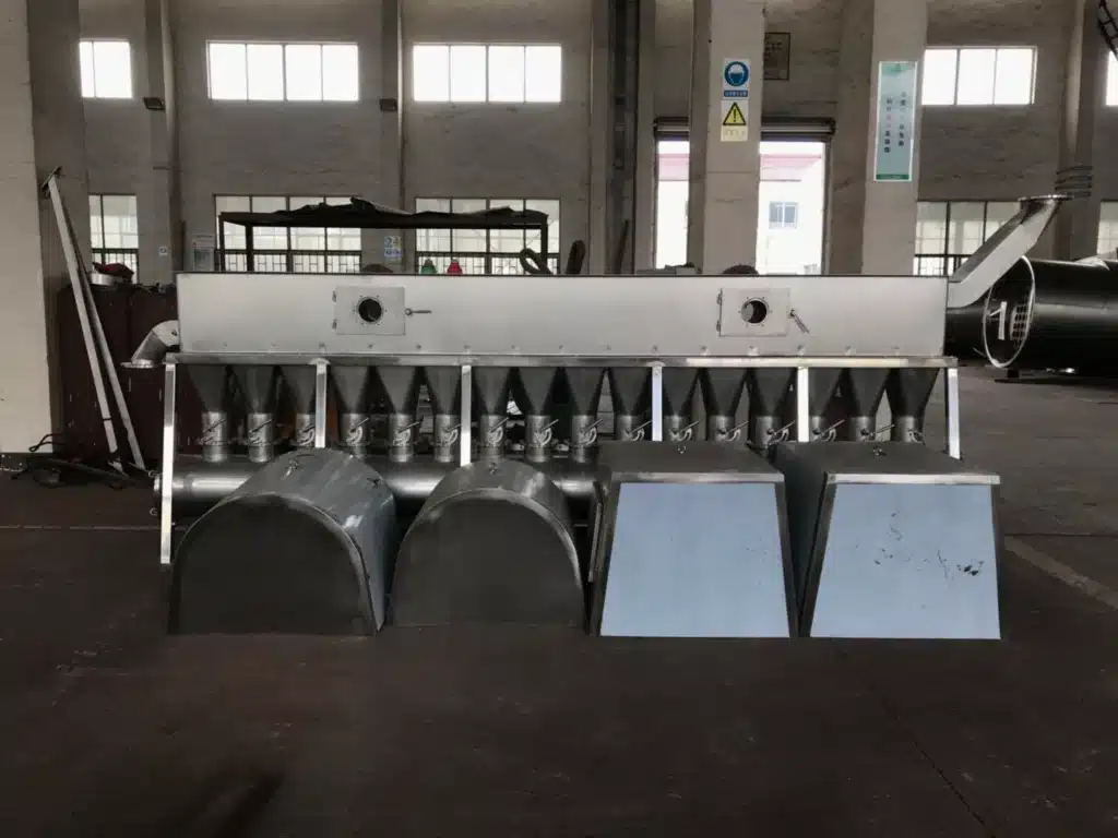 Sécheur à lit fluidisé horizontal dans un environnement industriel, avec de multiples structures coniques sous une longue chambre horizontale, indiquant la technologie du séchage fluidisé, le tout construit en acier inoxydable poli.